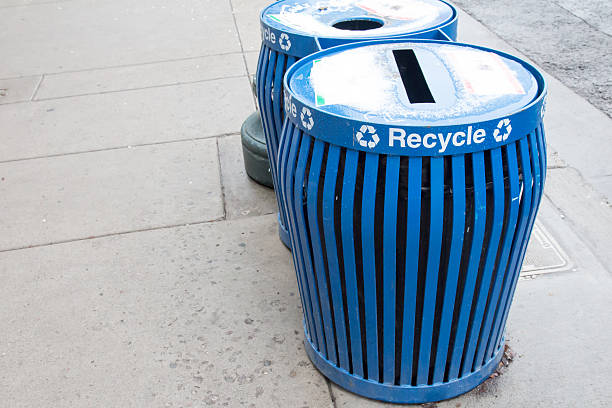 istock Blue recycling bins on a sidewalk 521419804