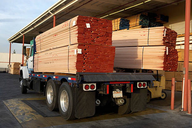 istock Stacks of Lumber Being Loaded onto Truck at Loading Dock 521419859