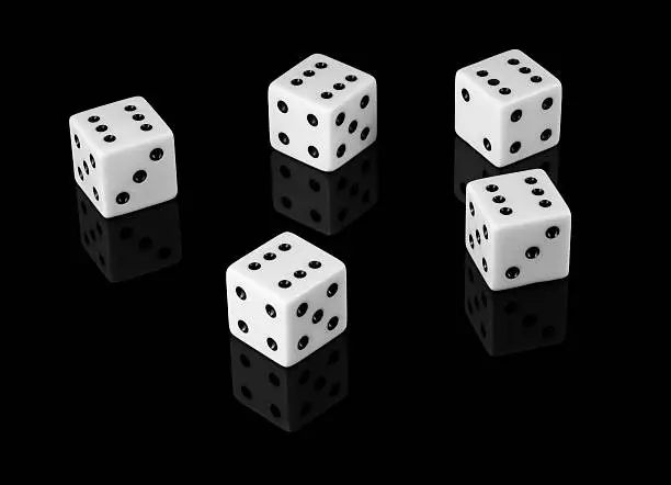 Five dice with sixes stacked high background with reflection.