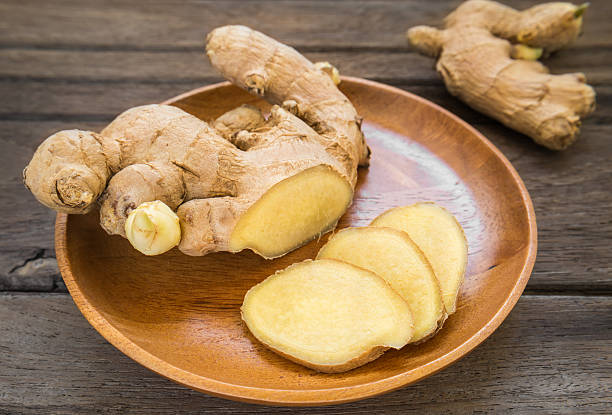 istock Ginger root sliced on wooden plate 521421533