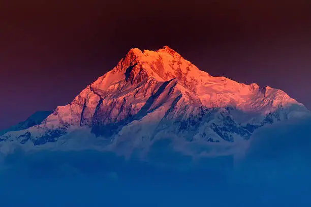 Beautiful  first light from sunrise on Mount Kanchenjugha, Himalayan mountain range, Sikkim, India. Blue coloured clouds surrounded the mountains at dawn
