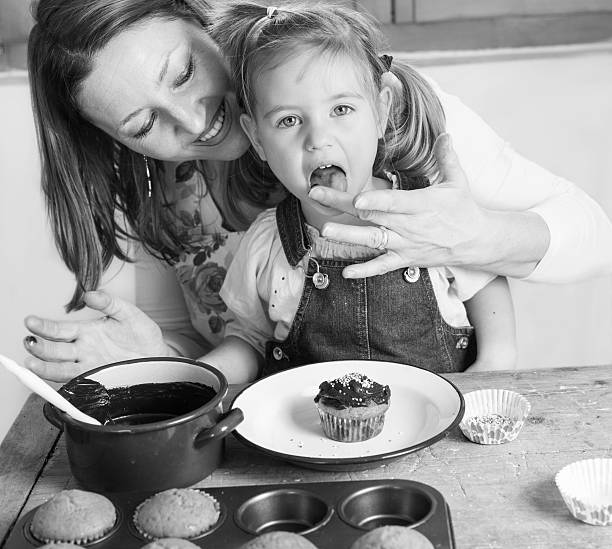 istock mother and daughter baking cupcakes 521425714
