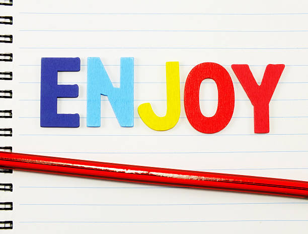 istock enjoy alphabet from colorful wooden on blank paper notebook 521426232