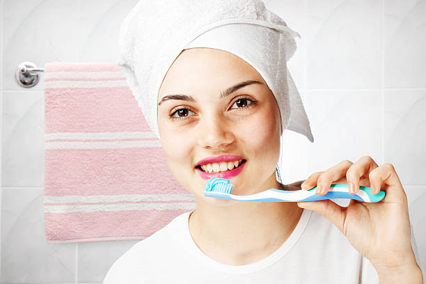 istock Smiling young girl brushing teeth 521432466
