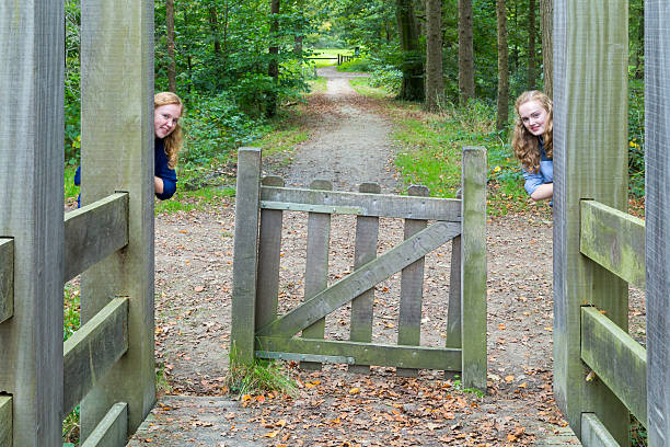 istock Two girls hiding at entry in nature 521435527