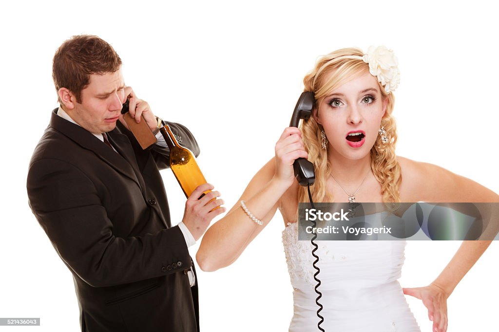 Wedding. Angry bride and groom talking on phone Wedding relationship difficulties. Angry woman and drunk man talking on the phone. Couple bride and groom quarrelling isolated on white. Addiction and alcoholism. Addiction Stock Photo