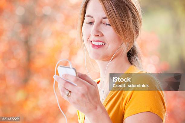 Woman Outdoors In Fall Listening To Music Stock Photo - Download Image Now - 40-44 Years, Adult, Adults Only