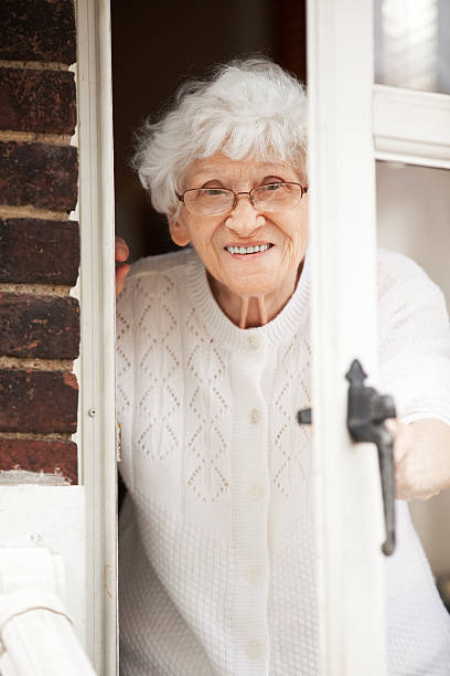 istock Senior Woman Peeking Though Door 521437235