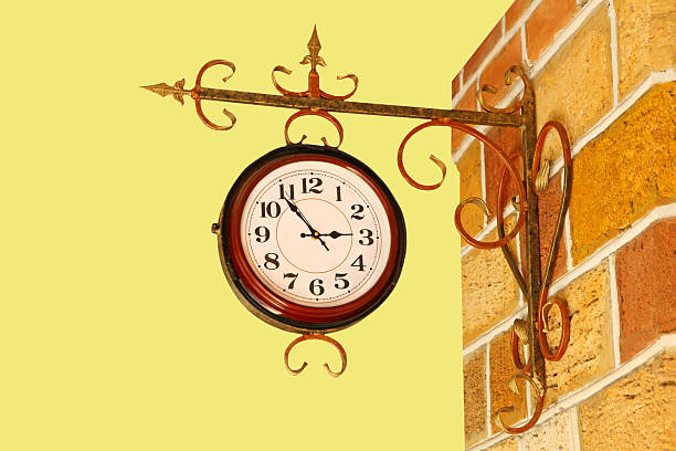 istock Vintage watch and brick wall on yellow. 521440303