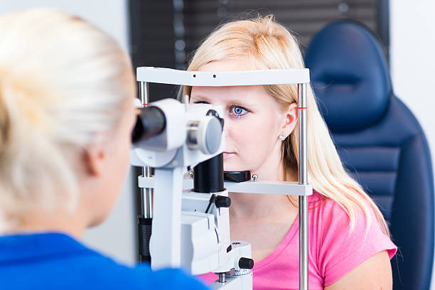 istock Pretty young woman having her eyes examined by optometrics 521441465