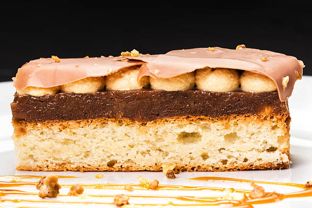 istock Layered dessert with caramel, nuts and chocolate on white plate, 521454949
