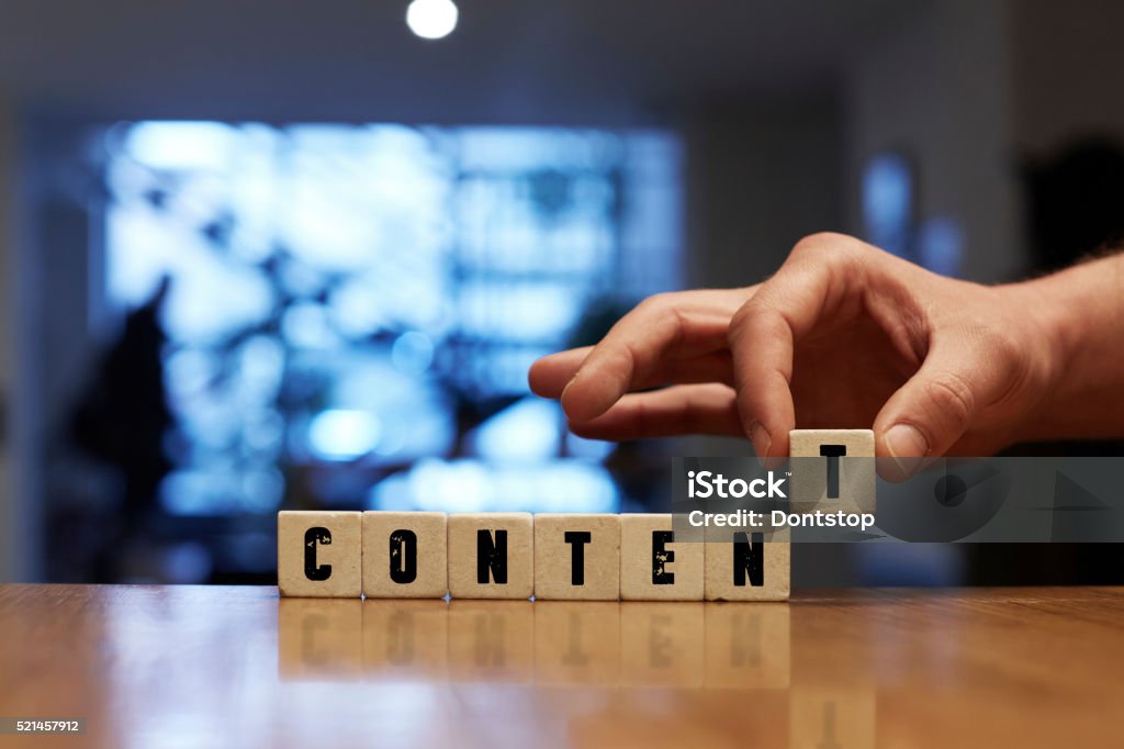 Content Concept with Alphabet Blocks Content Concept , Hand with alphabet blocks on wooden table Contented Emotion Stock Photo