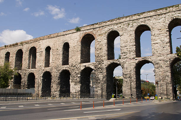 ISTANBUL, TURKEY - November 06, 2012: Valens Aqueduct (Bozdogan Su Kemeri) with cars and the city, Istanbul, Turkey . It was a water-providing system of the Eastern Roman capital Constantinpole