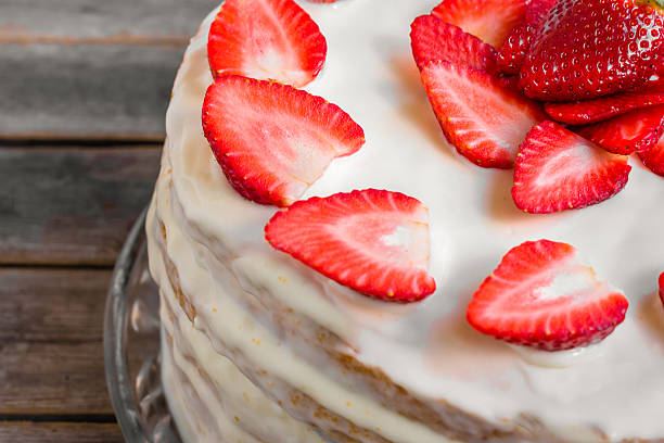 istock White cake decorated with strawberries on a wooden table 521460072