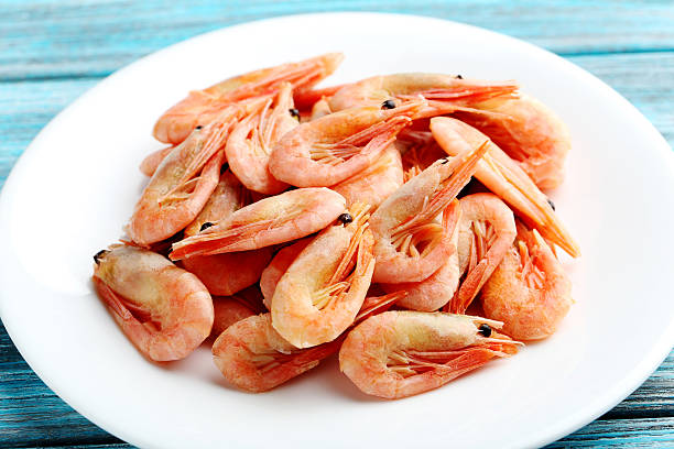 istock Fresh boiled shrimps on a blue wooden table 521461202