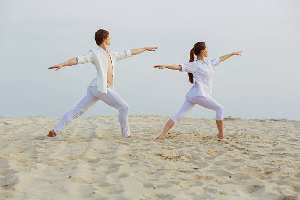 istock beautiful, athletic couple in white clothes making yoga exercis 521462842