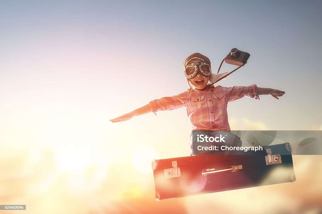 Dreams of travel Dreams of travel! Child flying on a suitcase against the backdrop of a sunset. Child Stock Photo