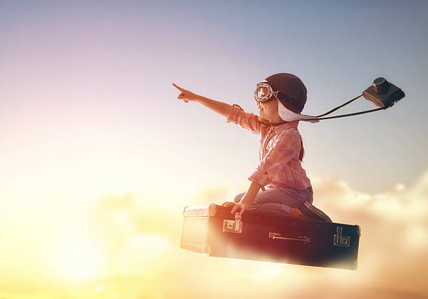 Dreams of travel Dreams of travel! Child flying on a suitcase against the backdrop of a sunset. fly stock pictures, royalty-free photos & images