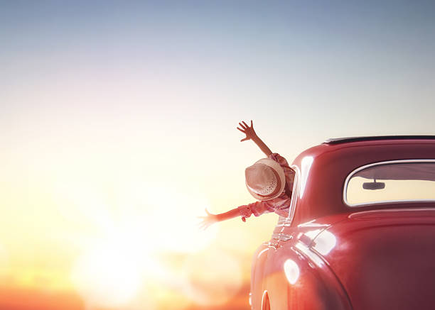 girl rides into the sunset Toward adventure! Girl relaxing and enjoying road trip. Happy girl rides into the sunset in vintage car. vintage people stock pictures, royalty-free photos & images