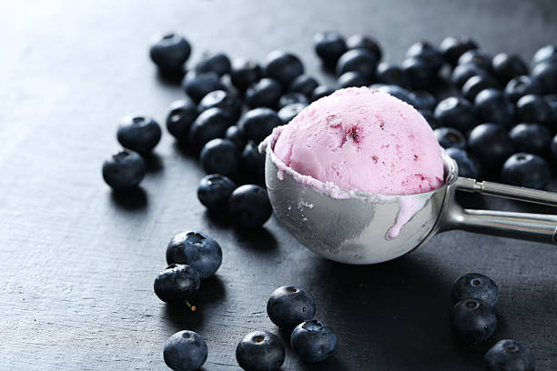 istock Ice cream with blueberries on black wooden background 521464804