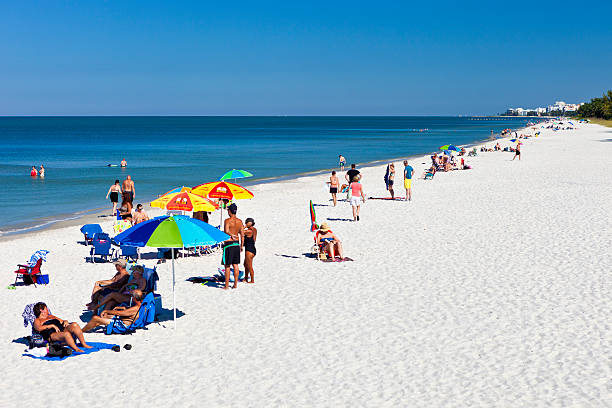 Naples Beach, Florida Naples, Florida, USA - October 20, 2014:  People enjoying the beach in Naples, Florida on a sunny day. naples beach stock pictures, royalty-free photos & images