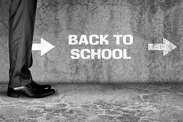 istock businessman standing back to school text written on dirty wall 521468656