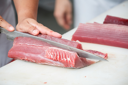 cutting tuna on a white table