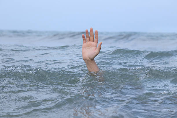 istock hand drowning in the sea 521471086