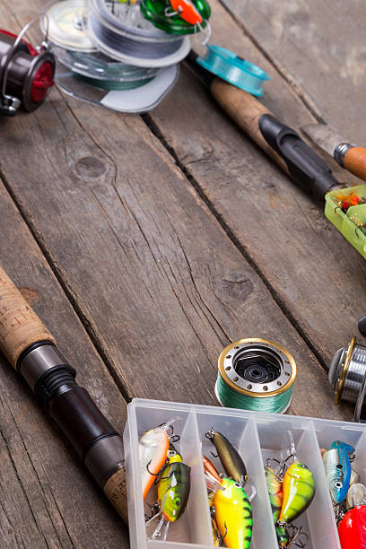 istock fishing tackles and baits on wooden board 521472660