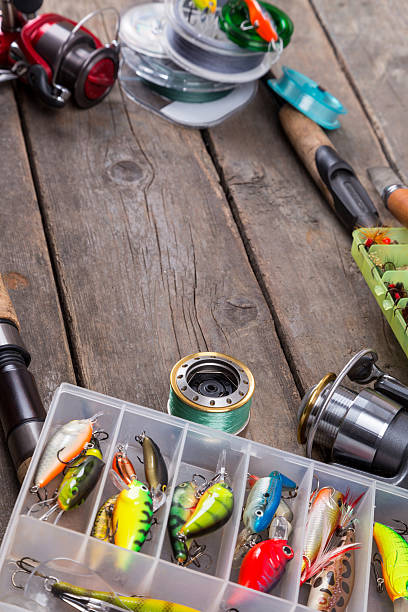 istock fishing tackles and baits on wooden board 521472704