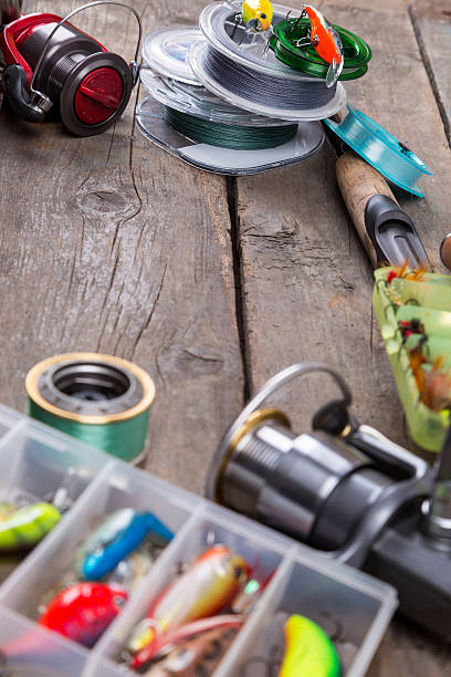 istock fishing tackles and baits on wooden board 521472828