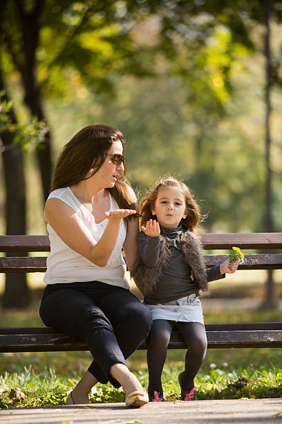 istock Mother and daughter sitting on a bench 521486183