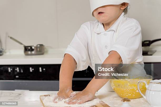 Little Child Baking In A Chefs Toque Stock Photo - Download Image Now - Activity, Apron, Baking