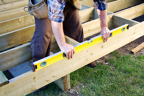 Is it level? Carpenter checking level of deck boards decking stock pictures, royalty-free photos & images