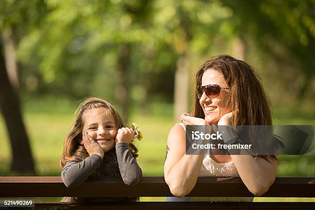Mother And Daughter Sitting On A Bench Stock Photo - Download Image Now - Adult, Autumn, Beautiful People