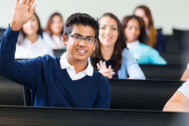 Indian teen boy raising hand to answer question in class Indian teen boy raising hand to answer question in class teenage high school girl raising hand during class stock pictures, royalty-free photos & images