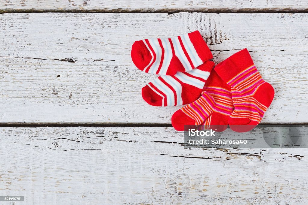 baby red striped socks baby red striped socks on a white wooden background. children's clothing.copy space for text Clothing Stock Photo