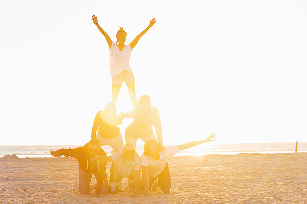 Friends making a pyramid on the beach of St.Peter-Ording