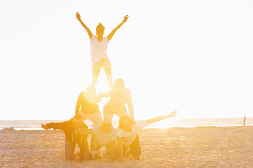 Friends making a pyramid on the beach of St.Peter-Ording