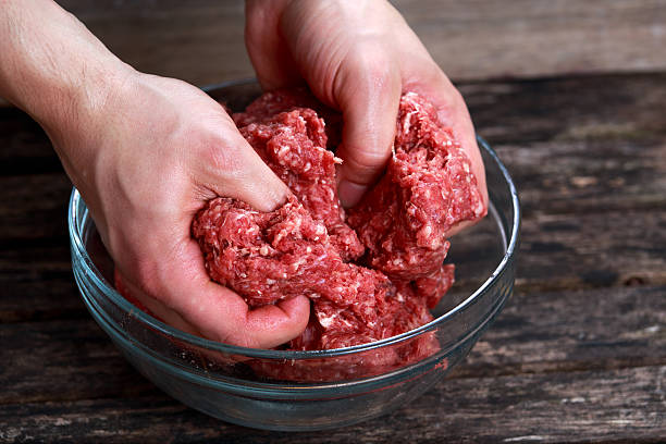 istock Man mixen beef mince by hand . 521492682