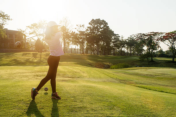 sucesso mulher asiática golfe deslumbrantes para o campo de golfe no verão - golf golf swing sunset golf course - fotografias e filmes do acervo