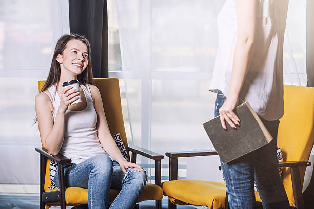 dos hermosas mujeres amigos hablando de sonrisas felices en casa - twin tips fotografías e imágenes de stock