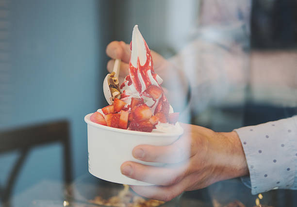 istock seller pours sauce on a soft frozen yogurt 521496148