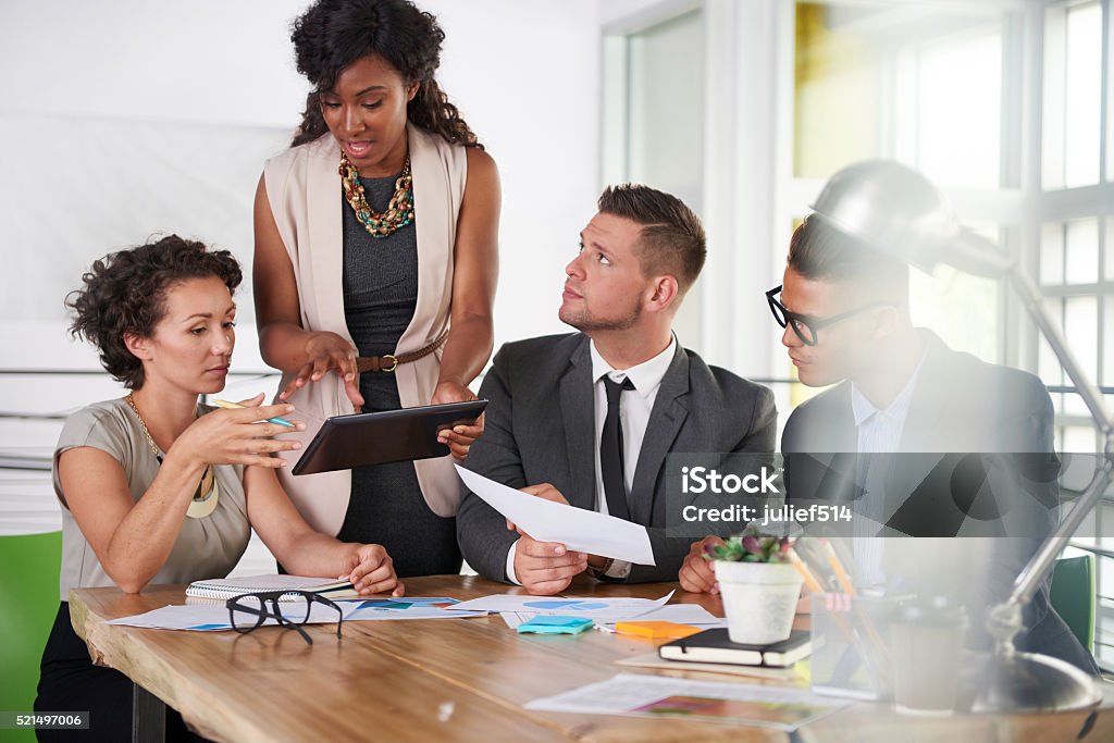 team of successful business people having a meeting in executive Candid photo of a corporate businesspeople group discussing strategies in professionnal indoors setting. Adult Stock Photo