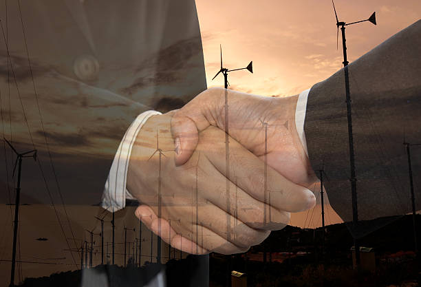 istock Double exposure business man handshake and wind energy industry concept. 521497500