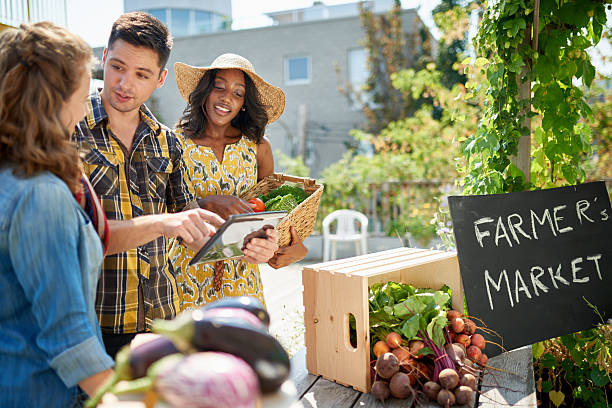 istock Friendly woman tending an organic vegetable stall at a farmer 521497740