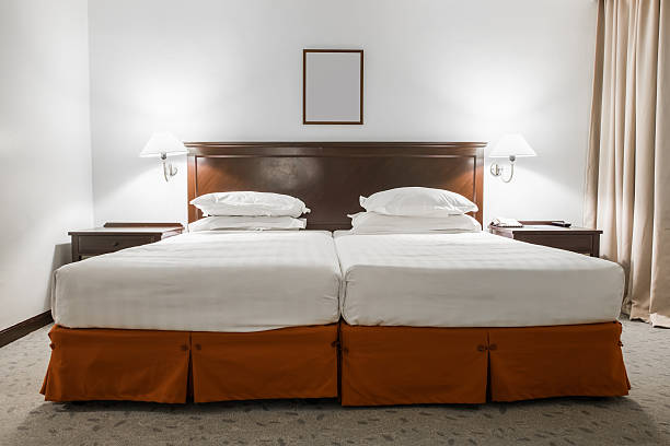 White twin bed with picture frame in hotel room