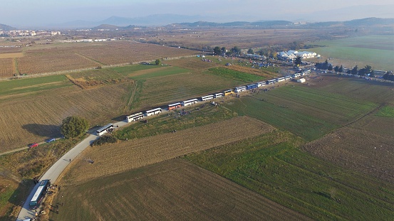 Idomeni, Greece - December 5, 2015: Aerial photo of the long line of buses waiting near the Idomeni refugee camp where the processing of the incoming refugees is not as fast as new refugees arriving. Drone photo.