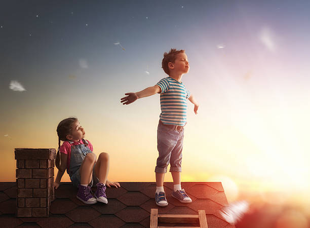 istock boy and girl playing on the roof 521506368