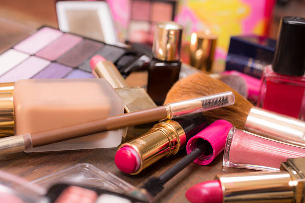 istock Pile of various cosmetics, make-up lie on wooden dressing table. 521506504